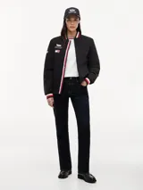 Campera estilo bomber de Tommy Hilfiger en colaboración con Cadillac Formula 1® Team, color negro. Cuenta con cuello tipo béisbol, cierre frontal de cremallera y ribetes tejidos a rayas rojas, blancas y azules en el cuello, puños y dobladillo. Presenta parches bordados del equipo en el pecho.
