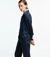 Camisa de satén color verde oliva, de manga larga con puños abotonados y cuello inglés.