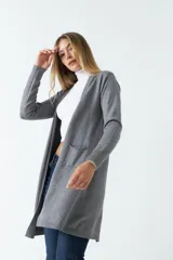 Saco largo de punto color gris, sin botones y con dos bolsillos pequeños al frente.