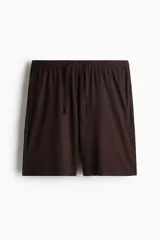 Conjunto de pijama de dos piezas color marrón oscuro, compuesto por una remera de manga corta con cuello redondo y un short con cintura elástica ajustable mediante cordón y bolsillos laterales.