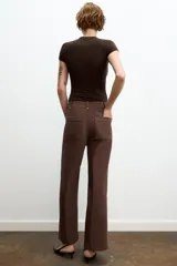 Jeans de tiro alto, pierna ancha y largo al tobillo, en denim celeste claro con efecto lavado. Presenta costura marcada en el centro de cada pierna y cierre frontal con cremallera y botón.