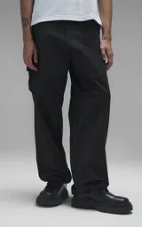Pantalón cargo de estilo técnico en color negro, confeccionado en textil memory con acabado sutilmente brillante. Presenta una silueta oversize, cinturón regulable integrado con hebilla de encastre, dos bolsillos laterales, dos bolsillos cargo de gran tamaño y un bolsillo trasero.