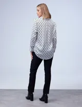 Camisa de satén estampado en blanco y negro, con cuello con solapa, escote en V y abertura central con botones.