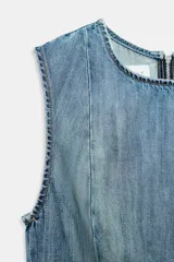 Vestido corto de denim sin mangas con cuello redondo. Presenta costuras marcadas en el cuerpo y un bajo asimétrico con vuelo.