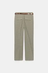 Pantalón de tiro alto color negro, de corte recto y pinzas frontales. Incluye un cinturón delgado de cuero marrón con hebilla metálica dorada.