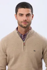 Buzo tejido de lana con cuello alto y medio cierre metálico frontal. Presenta puños y ruedo acanalados, con logo bordado en el pecho.