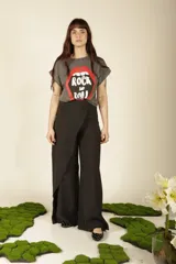 Pantalón negro de corte amplio y tiro alto, con diseño envolvente en la parte frontal que crea un efecto de falda sobre el pantalón.