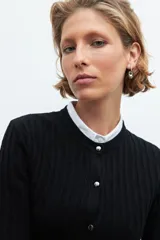 Cardigan negro de punto acanalado, con cuello redondo y cierre frontal de botones plateados.