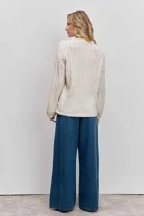 Sweater de tejido de punto color bordó, con cuello alto, mangas largas con puños ajustados y diseño de trenzas verticales.