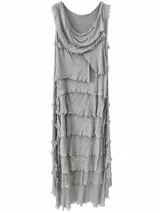 Vestido largo gris visón con múltiples volados superpuestos y bordes desmechados, de corte asimétrico y tirantes anchos.
