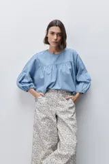 Pantalón de tiro alto con silueta amplia y piernas rectas, confeccionado en algodón con estampado floral. Cuenta con cierre frontal de botón y cremallera, y bolsillos laterales funcionales.