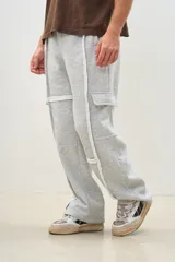 Pantalón de jogging gris melange de corte ancho, con bolsillos laterales y detalles de costuras blancas a contraste.
