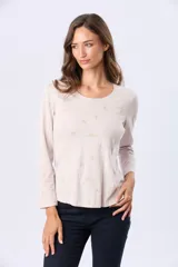 Remera manga larga de algodón color beige, con estampado sutil de pequeñas aves y escote redondo.