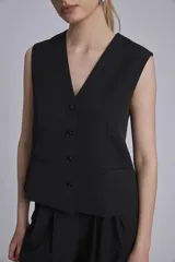 Chaleco negro con escote en V y cierre frontal con botones.