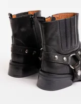 Bota corta negra de cuero vacuno con estribo desmontable, suela de caucho, cierre interno y punta redonda.