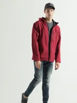 Campera negra con capucha y cierre frontal, de corte clásico y bolsillos laterales con cierre.