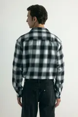 Camisa de franela de algodón suave con estampado a cuadros, cuello inglés, cierre frontal de botones, mangas largas con puños abotonados y bajo redondeado.