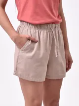 Short de tela de algodón color beige, con cintura elástica fruncida y cordón ajustable. Presenta bolsillos laterales.