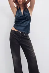 Top de tejido satinado color negro, con cuello halter anudado en la nuca y escote drapeado.