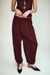Pantalón de tiro medio con cintura elástica, diseño holgado y bajo con puño ajustable mediante lazada.