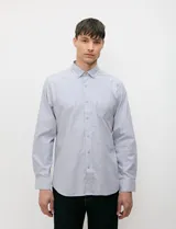 Camisa de manga larga de tejido Oxford color celeste, con cuello button-down, cierre frontal de botones y un bolsillo aplicado en el pecho.