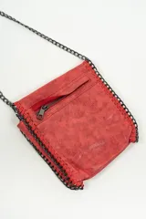 Bandolera pequeña de color negro con acabado texturizado y detalles de costuras reforzadas en los bordes. Cuenta con una correa larga de cadena metálica en tono oscuro.