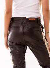 Pantalón de cuero genuino color chocolate, con paneles laterales en cuero beige. Presenta ajuste con cordones en la cintura y en los laterales de las piernas, permitiendo regular el entalle.