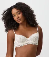Soutien media taza Lov confeccionado en encaje floral blanco, sin relleno y con aro estructurado. Presenta breteles finos regulables, base alargada con acabado ondulado y diseño semitransparente.