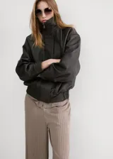 Pantalón de corte ancho, color tostado con sutiles rayas verticales en tonos marrones y oscuros, confeccionado en poliéster.