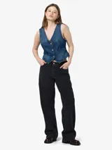 Chaleco de jean azul con cuello en V, cierre frontal con botones metálicos, bolsillos delanteros y corte a la cintura.