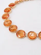 Collar corto con eslabones dorados y cuentas circulares facetadas color ámbar.