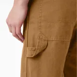 Pantalón de trabajo Dickies color marrón, de corte recto y holgado, confeccionado en lona de algodón prelavada. Cuenta con múltiples bolsillos y presilla para martillo.