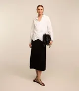 Pollera midi negra de corte evasé con cintura alta y textura plisada.