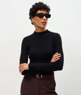 Suéter de punto canelado color negro, con cuello alto y manga larga. Presenta un diseño ajustado al cuerpo y una textura suave, ideal para combinar con diferentes estilos.