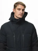Campera puffer con capucha, de diseño bicolor en tonos gris topo y negro. Presenta cierre frontal con solapa de botones, bolsillos laterales y ajuste en los puños.
