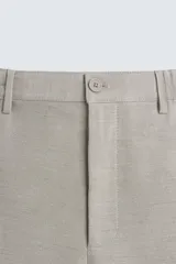 Bermuda de algodón color blanco, de corte relajado, con cintura elástica, bolsillos frontales y bolsillos traseros de plastrón. Cierre frontal con cremallera y botón.