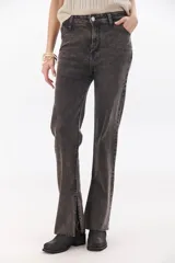 Pantalón de jean gris oscuro, de corte recto, tiro alto y tajos laterales en el ruedo.