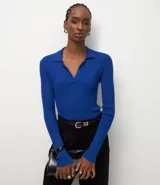 Blusa de manga larga con textura acanalada, cuello polo y escote en V. Confeccionada en tejido de viscosa y poliamida, presenta un corte regular que se ajusta de forma anatómica al cuerpo.