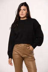 Buzo tejido de punto color beige, con cuello redondo, mangas largas con puños ajustados y diseño de corte cropped.