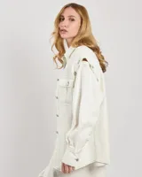 Chaqueta estilo camisa de algodón elástico color blanco, con mangas desmontables y botones. Costuras en contraste en toda la prenda y corte ligeramente oversize.