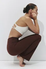 Leggings deportivos acampanados de color marrón, tiro alto y diseño ajustado con perneras amplias hacia el dobladillo.