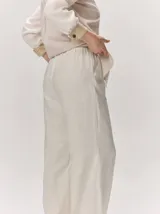 Pantalón de lino color tostado, de corte amplio y fluido con piernas acampanadas.