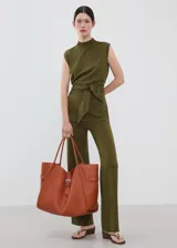 Chaleco de punto fino color verde militar, con diseño recto, cuello perkins, manga corta y detalle de cinturón para atar en la cintura.