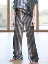 Pantalón de lino y algodón a rayas verticales en tonos celeste y blanco, con corte palazzo y volados en el lateral.