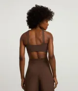 Top deportivo de mujer con diseño halter, confeccionado en microfibra de poliamida y elastano. Cuenta con copas integradas y breteles anchos en la espalda para mayor soporte.