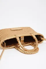 Minibolso trenzado Bimba y Lola de color dorado metalizado, confeccionado en piel vacuna. Posee asas de mano rígidas y correa ajustable para hombro, con etiqueta frontal de piel con el logo de la marca.