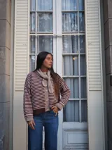 Cardigan de punto a rayas horizontales en tonos marrón y beige, con cierre frontal de botones y detalles en rib en los puños, el cuello y el ruedo.