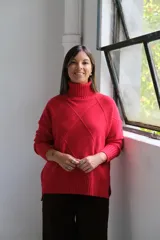 Polerón de punto color rojo con cuello alto y diseño de rombos texturizados. Presenta mangas largas con puños acanalados y un corte holgado con ruedo asimétrico.