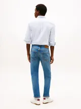 Pantalón de jean Tommy Hilfiger modelo Denton, de corte recto y color azul con efecto lavado. Presenta diseño clásico de cinco bolsillos, cierre de botón con cremallera y costuras reforzadas.