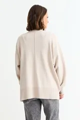 Cardigan de punto color fucsia, con cuello en V, cierre frontal con botones y bolsillos laterales. Presenta un diseño holgado con mangas largas y puños acanalados.